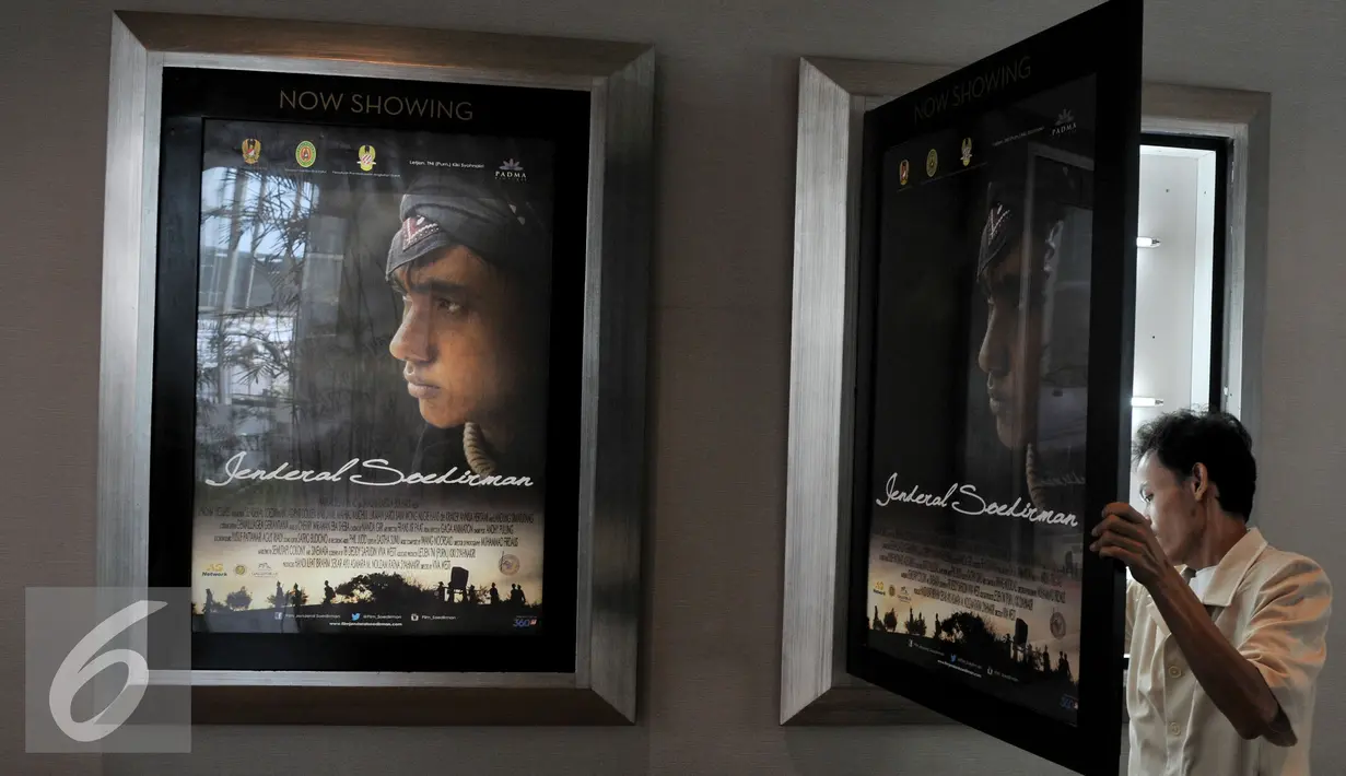 Pekerja memasang poster film Jendral Soedirman sebelum dimulainya pemutaran perdana Film Jenderal Soedirman, Jakarta, Senin (24/8/2015). Film tersebut mengisahkan Jenderal Soedirman yang memimpin perang gerilya (1945-1949).(Liputan6.com/Andrian M Tunay)