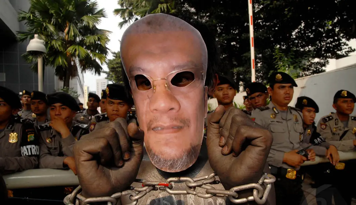 Selain dirantai, para demonstran juga memakai topeng Mohammad Riza Chalid  di depan Gedung KPK, Jakarta, Kamis (3/7/14). (Liputan6.com/Miftahul Hayat) 
