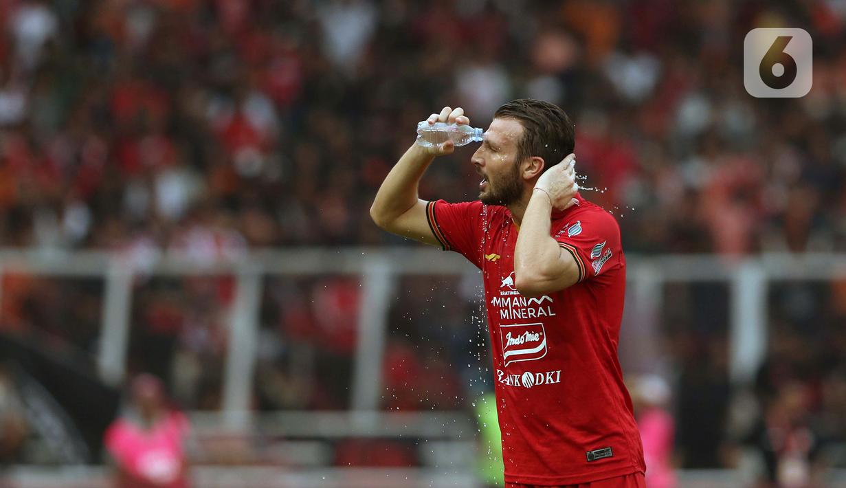 Pemain belakang Persija, Marco Motta mengguyur wajahnya saat melawan Borneo FC pada laga pekan pertama Shopee Liga 1 Indonesia 2020 di Stadion Gelora Bung Karno, Jakarta, Minggu (1/3/2020). Persija unggul 3-2. (Liputan6.com/Helmi Fithriansyah)