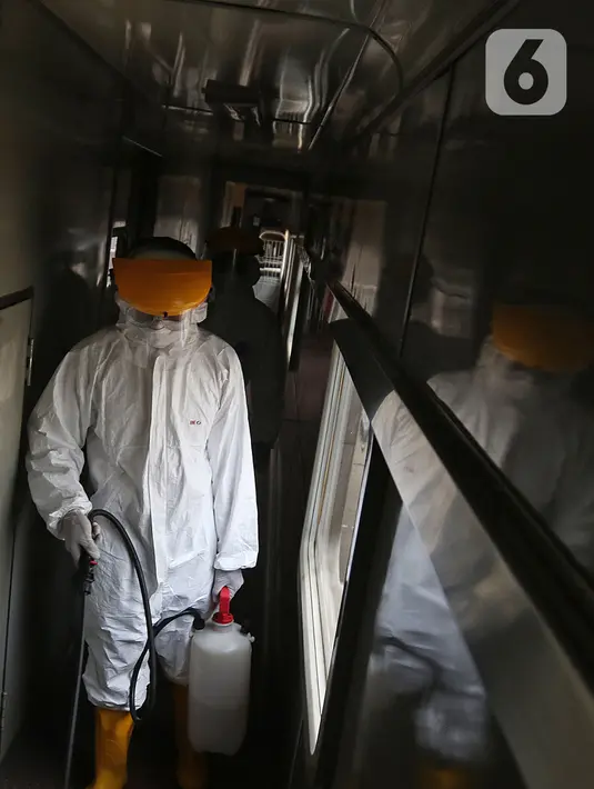 Petugas melakukan penyemprotan disinfektan pada gerbong kereta api di Stasiun Pasar Senen, Jakarta, Minggu (15/3/2020). PT KAI Daop I Jakarta melakukan penyemprotan disinfektan dan pembersihan KA jarak jauh untuk antisipasi dan pencegahan penyebaran COVID-19. (Liputan6.com/Herman Zakharia)