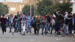 Para pengunjuk rasa melakukan aksi protes di luar kantor pemerintah setempat di Kasserine, Tunisia, Kamis (21/1). Para pengangguran muda turun ke jalan memprotes keterpurukan ekonomi dan sulitnya lapangan kerja. (REUTERS/Amine Ben Aziza)
