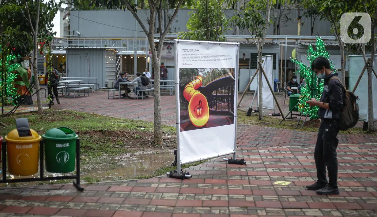Pengunjung mengamati karya Pameran Fotografi Rekam Jakarta 2019-2020 di Thamrin 10, Jakarta, Jumat (4/12/2020). Pameran yang mengangkat tema Ragam Cerita Ibu Kota Sebelum dan Saat Pandemi COVID-19 tersebut berlangsung hingga 13 Desember 2020. (Liputan6.com/Faizal Fanani)