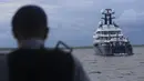 Polisi setempat mendekati sebuah kapal pesiar mewah (yacht) bernama Equanimity yang tengah berada di Teluk Benoa, Bali, Rabu (28/2). Berdasarkan Pengadilan AS, kapal Equanimity dimiliki oleh seorang miliuner asal Malaysia Jho Low. (Rully Prasetyo/AFP)