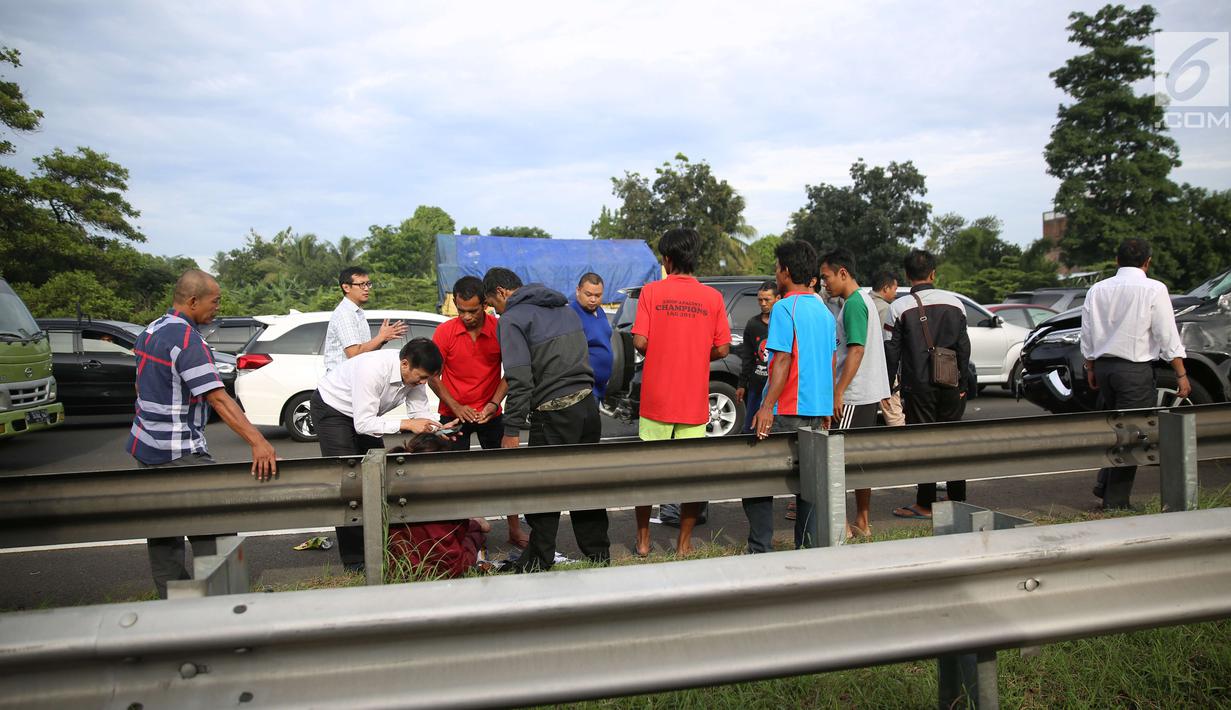 Pengendara membantu korban kecelakaan antara mobil Toyota Fortuner dengan truk boks Colt Diesel di tol Jagorawi, Kamis (28/12). Kecelakaan tersebut terjadi tepatnya di KM 23 arah Jakarta. (Liputan6.com/Angga Yuniar)