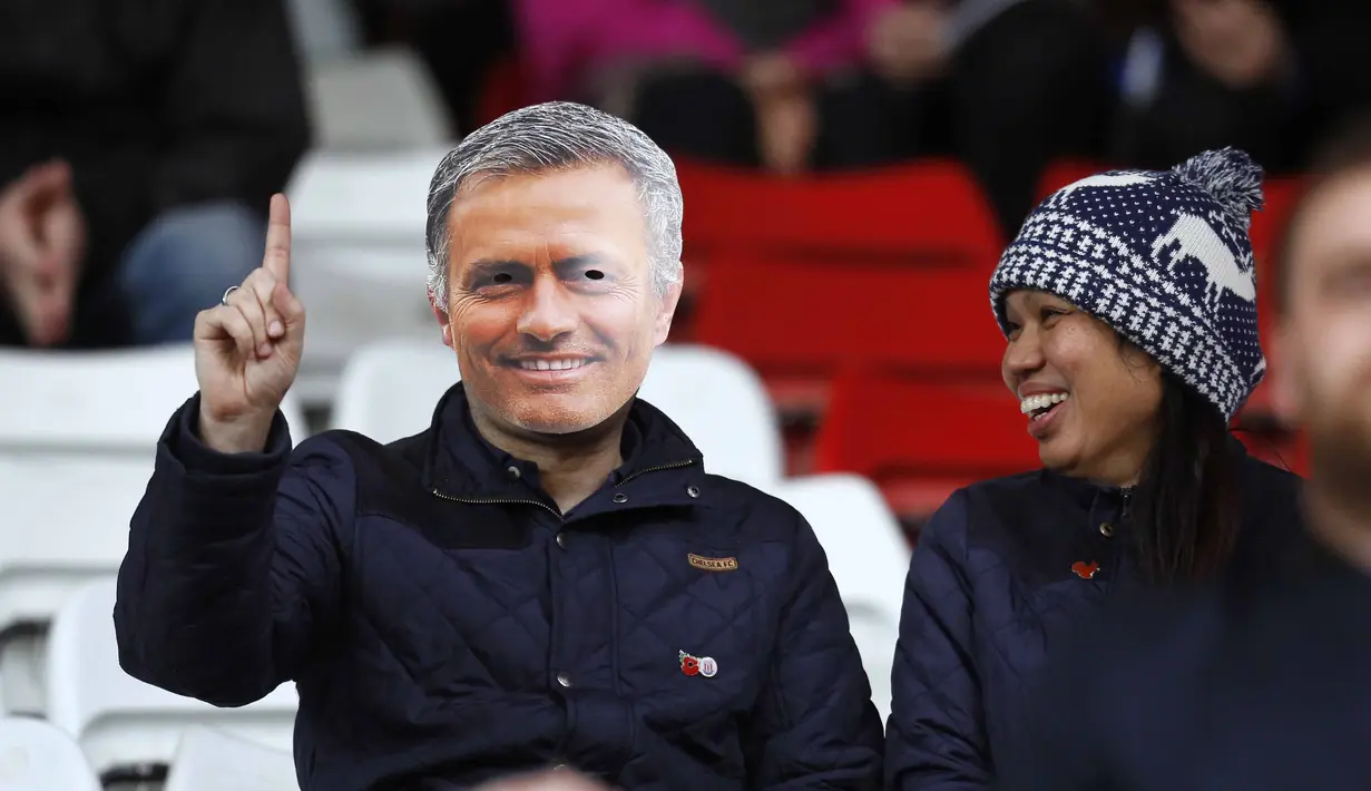  Seorang suporter menggunakan topeng pelatih Chelsea Jose Mourinho pada laga Liga Premier Inggris di Stadion Britania, Minggu (8/11/2015) dini hari WIB. Mourinho dilarang mendampingi timnya oleh Football Association ( FA ). ( Reuters/ Ed Sykes)