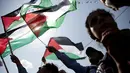 Warga Palestina melambaikan bendera nasional mereka saat menunggu live-screening pidato Presiden Mahmud Abbas sebelum pengibaran bendera Palestina di markas besar PPB di New York, Rabu (30/9/2015). (AFP PHOTO/ABBAS Momani)