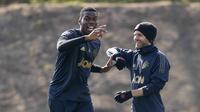 Gelandang Manchester United, Paul Pogba, bercanda dengan Juan Mata saat sesi latihan jelang laga Liga Champions di Manchester, Selasa (9/4). Manchester United akan berhadapan dengan Barcelona. (AP/Ian Hodgson)