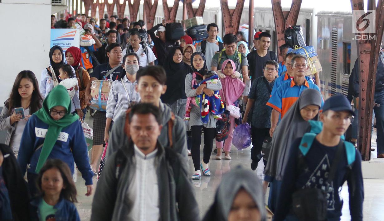 Penumpang membawa barang mereka usai turun dari kereta api jurusan Jawa Tengah tiba di Stasiun Senen, Jakarta, Rabu (28/6). (Liputan6.com/Angga Yuniar)