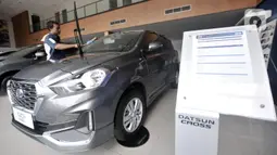 Pekerja membersihkan mobil Datsun Go+ Panca di Diler Nissan kawasan Pulogadung, Jakarta, Rabu (27/11/2019). Pabrik mobil Datsun akan dialihfungsikan untuk memproduksi mesin mobil jenis lain dan lebih fokus mengembangkan kendaraan listrik. (merdeka.com/Iqbal Nugroho)