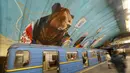 Penumpang melewati kereta di bawah mural yang menghiasi dinding stasiun metro bawah tanah kota di Kyiv, Ukraina, Rabu, (29/1/2020). (AP Photo / Efrem Lukatsky)