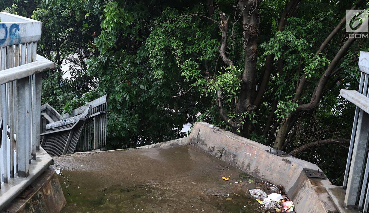 Suasana jembatan penyeberangan orang yang rusak di Terminal Kampung Rambutan, Jakarta, Senin (28/1). Kondisi JPO yang sebagian pagar pembatasnya rusak tersebut membahayakan pejalan kaki apabila tidak segera diperbaiki. Liputan6.com/Immanuel Antonius