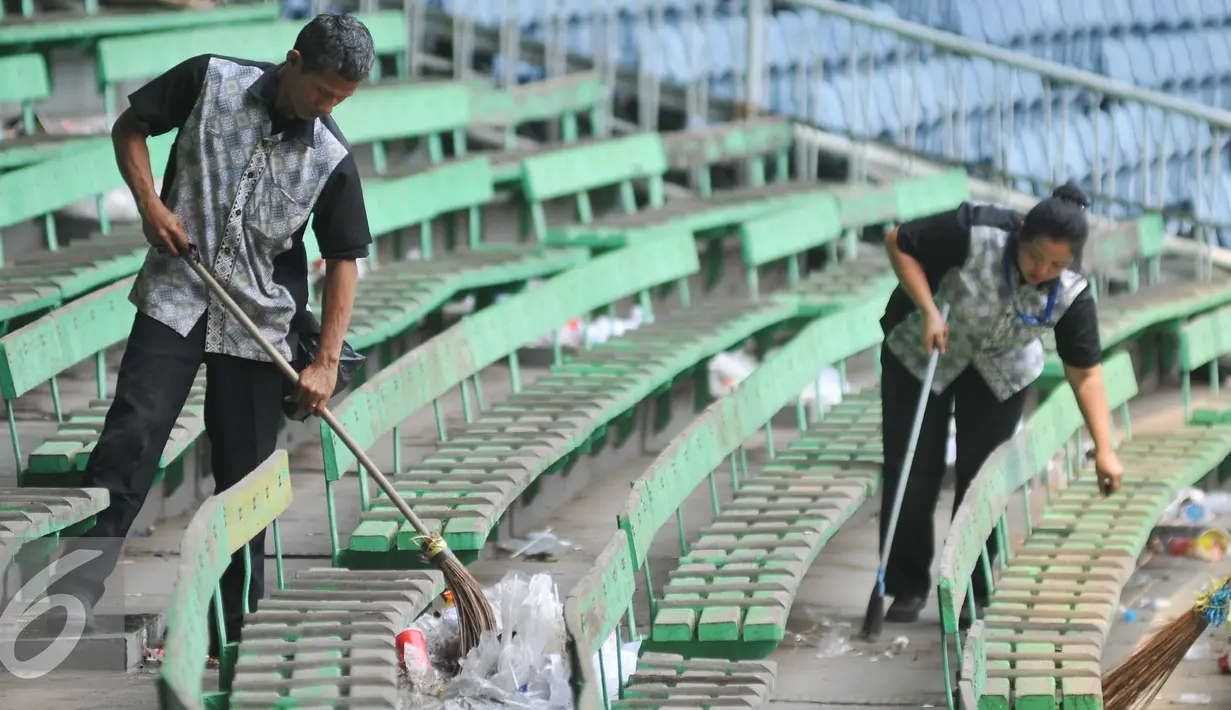Petugas kebersihan pengelola stadion GBK membersihkan sampah usai pertandingan final piala presiden di Stadion GBK, Jakarta (19/10/15). Pertandingan final tersebut dimenangkan oleh Persib Bandung 2-0. (Liputan6.com/Gempur M Surya).