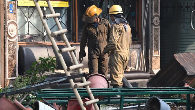 Personel pemadam kebakaran berada di luar Hotel Arpit Palace setelah memadamkan kebakaran di Distrik Karol Bagh, New Delhi, Selasa (12/2). Sebagian besar korban sedang tidur saat kebakaran terjadi. (Prakash SINGH / AFP)