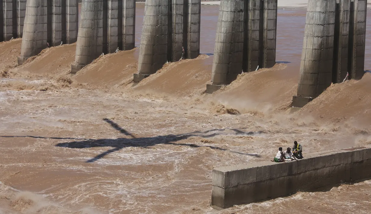 Seorang Angkatan Udara India bersiap  menyelamatkan dua di antara empat nelayan yang terperangkap dalam banjir di Sungai Tawi di Jammu, India (19/8/2019). Permukaan air di banyak sungai di India utara meningkat setelah hujan lebat di musim hujan. (AP Photo/Channi Anand)