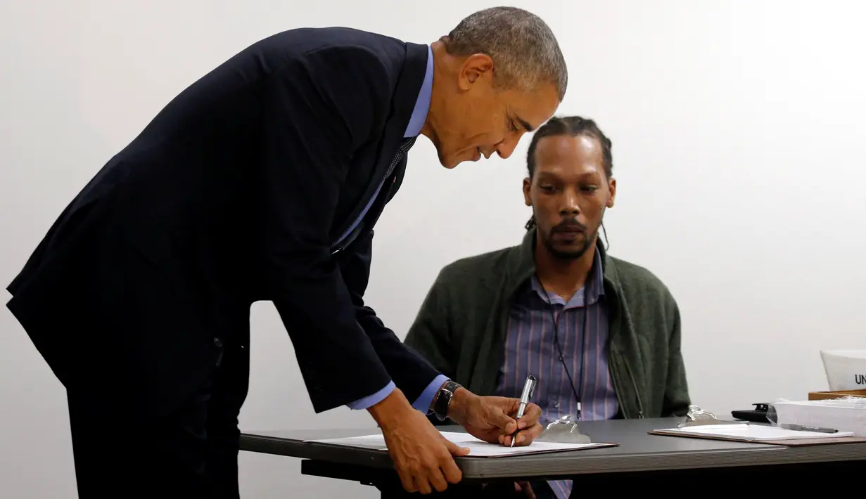 Presiden AS Barack Obama mengisi buku tamu setibanya di TPS awal di pusat kota Chicago, Illinois, Jumat (7/10). Obama memberikan suaranya lebih dahulu untuk Pilpres AS pada 8 November 2016 mendatang. (REUTERS/Jonathan Ernst)