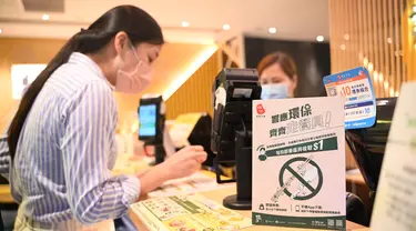 Sebuah tanda bertuliskan bahwa restoran tersebut tidak akan menyediakan peralatan makan plastik sekali pakai kepada pelanggan di Hong Kong, Senin (22/4/2024). (Peter PARKS / AFP)
