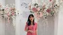 Fita Anggriani mengenakan v-neck dress dengan detail pleats pada rok. [@fitaangriani].