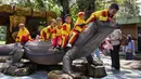 Beberapa murid taman kanak-kanak duduk di atas patung komodo di Kebun Binatang Surabaya, Jawa Timur, pada Rabu 29 April 2026. (JUNI KRISWANTO/AFP)