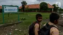 Dua orang murid pulang usai mengikuti aktivitas belajar mengajar di SDN Samudrajaya 04, Desa Samudrajaya, Kecamatan Tarumajaya, Kabupaten Bekasi, Jawa Barat, Selasa (21/1/2020). Murid SDN Samudrajaya 04 terpaksa belajar di gedung sekolah yang rusak sejak tahun 2014. (merdeka.com/Imam Buhori)