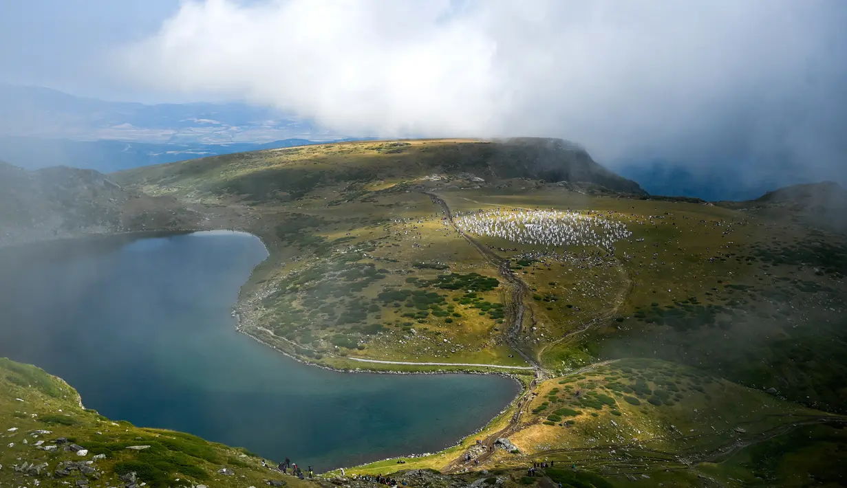 Anggota gerakan keagamaan internasional Persaudaraan Putih melakukan ritual tarian di puncak Gunung Rila, dekat Danau Babreka, Bulgaria, 19 Agustus 2021. Para anggota menampilkan tarian meditasi khusus yang dikenal sebagai "paneurhythmy". (NIKOLAY DOYCHINOV/AFP)
