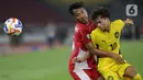 Pemain Timnas Indonesia U-23, Robi Darwis (kiri) berebut bola dengan Mohammad Haykal Danish Bin Mohd Haizon (Malaysia) pada laga lanjutan Grup A Piala AFF U-23 2025 di Stadion Utama Gelora Bung Karno, Jakarta, Senin (21/7/2025). (Liputan6.com/Helmi Fithriansyah)
