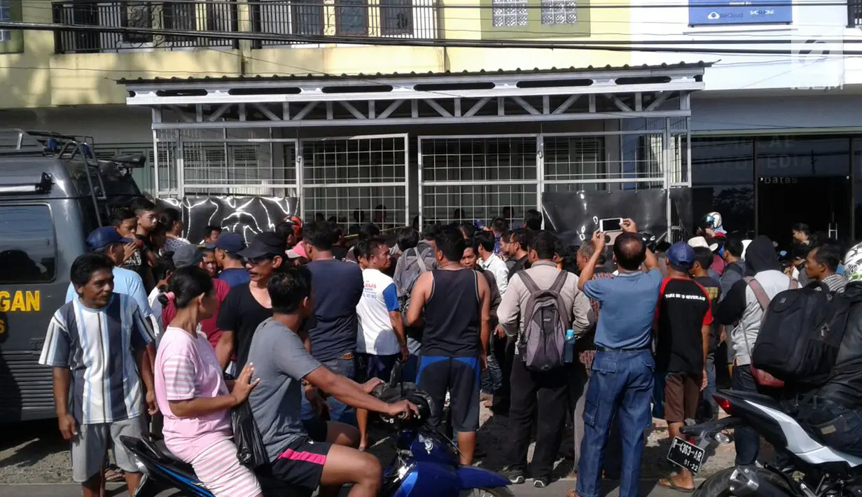 Warga berkumpul di depan pabrik pil PCC, Pabuaran, Purwokerto (19/9). Dalam pengrebekan ini, Polisi menemukan sejumlah ember yang berisi pil PCC siap edar, bahan Baku, alat timbangan, mesin pencetak dan lain sebagainya. (Liputan6.com/Pool/Frans Fadlan)