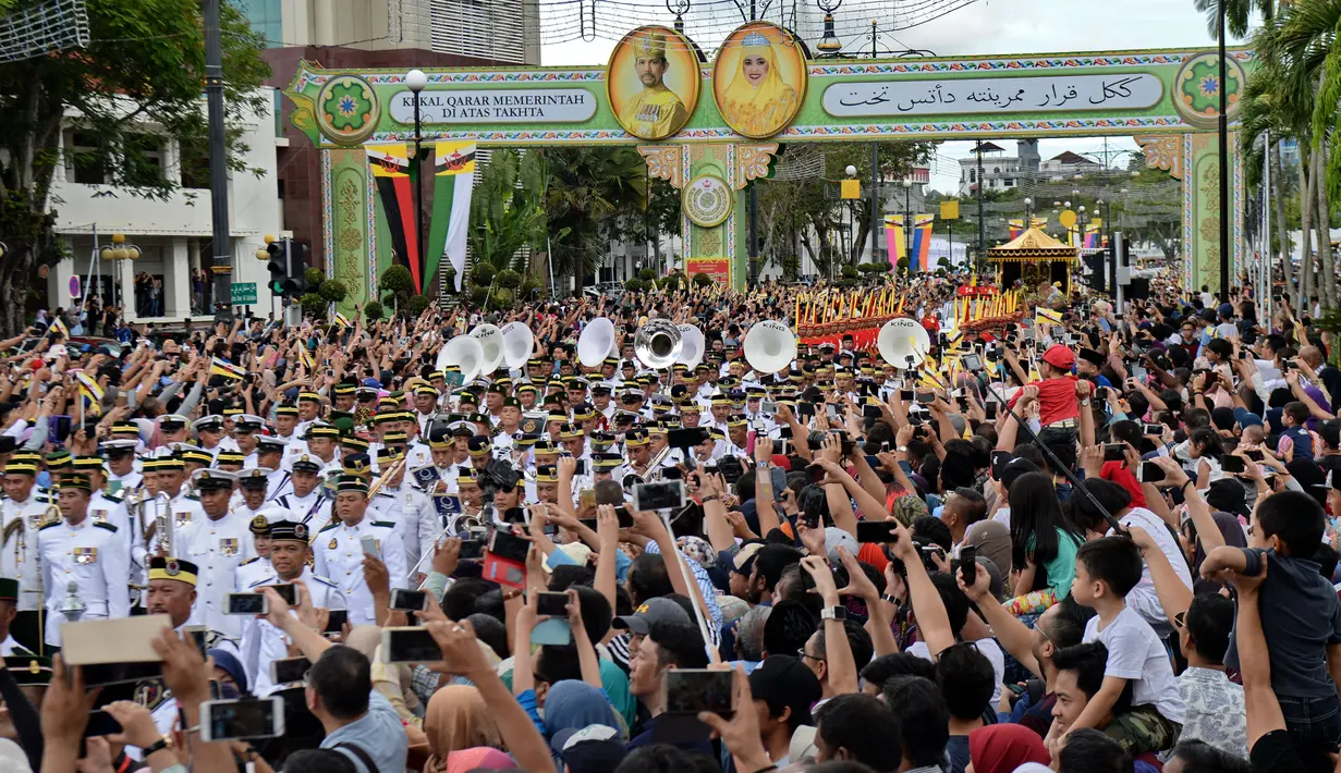 Ribuan warga memadati prosesi Golden Jubilee menunggu kadatangan Sultan Hassanal Bolkiah dan Ratu Saleha Brunei di Bandar Seri Begawan (5/10). Perayaan tersebut menandai 50 tahun bertahta. (AFP PHOTO / Roslan Rahman)