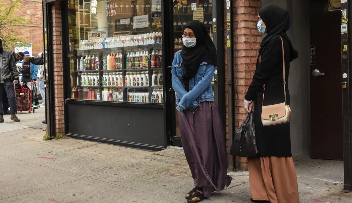 Dua wanita mengantre makan Halal gratis untuk Iftar selama bulan suci Ramadan di depan Masjid Taqwa di Bedford-Stuyvesant, Brooklyn, New York (14/5/2020). Acara ini diorganisir oleh Wakil Advokat Publik Kashif Hussain bersama Presiden Borough Brooklyn, Eric Adams. (Stephanie Keith/Getty Images/AFP)