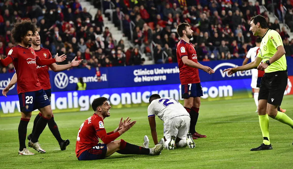 Pemain Osasuna memprotes keputusan wasit yang memberikan penalti kedua kepada Real Madrid pada pertandingan sepak bola La Liga Spanyol di Stadion El Sadar, Pamplona, Spanyol, 20 April 2022. Real Madrid menang 3-1. (AP Photo/Alvaro Barrientos)