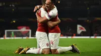 Selebrasi Aubameyang dan Sokratis Papastathopoulus pada leg 2, babak 16 besar Liga Europa yang berlangsung di stadion Emirates, London, Jumat (22/2). Arsenal menang 3-0 atas Bate Borisov. (AFP/Glyn Kirk)