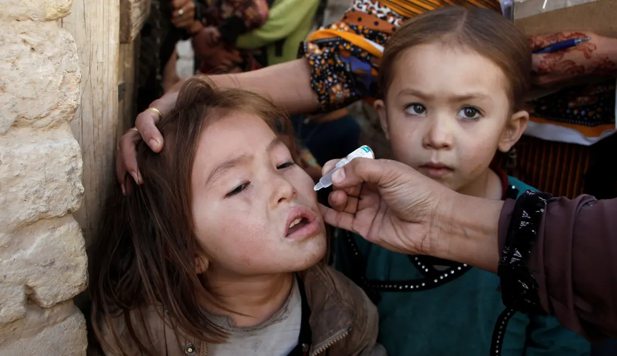 Petugas memberikan imunisasi polio di sepanjang jalan di Quetta, Pakistan, Senin (2/1). (REUTERS/Naseer Ahmed)