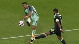 Cristiano Ronaldo (kiri) melepaskan tembakan melewati pemain Wales, Ashley Williams pada semi-final Piala Eropa 2016 di Stadion Parc Olympique Lyonnais, DÈcines-Charpieu, Prancis, Kamis (7/7/2016) dini hari WIB. (AFP/Jean-Philippe Ksiazek)
