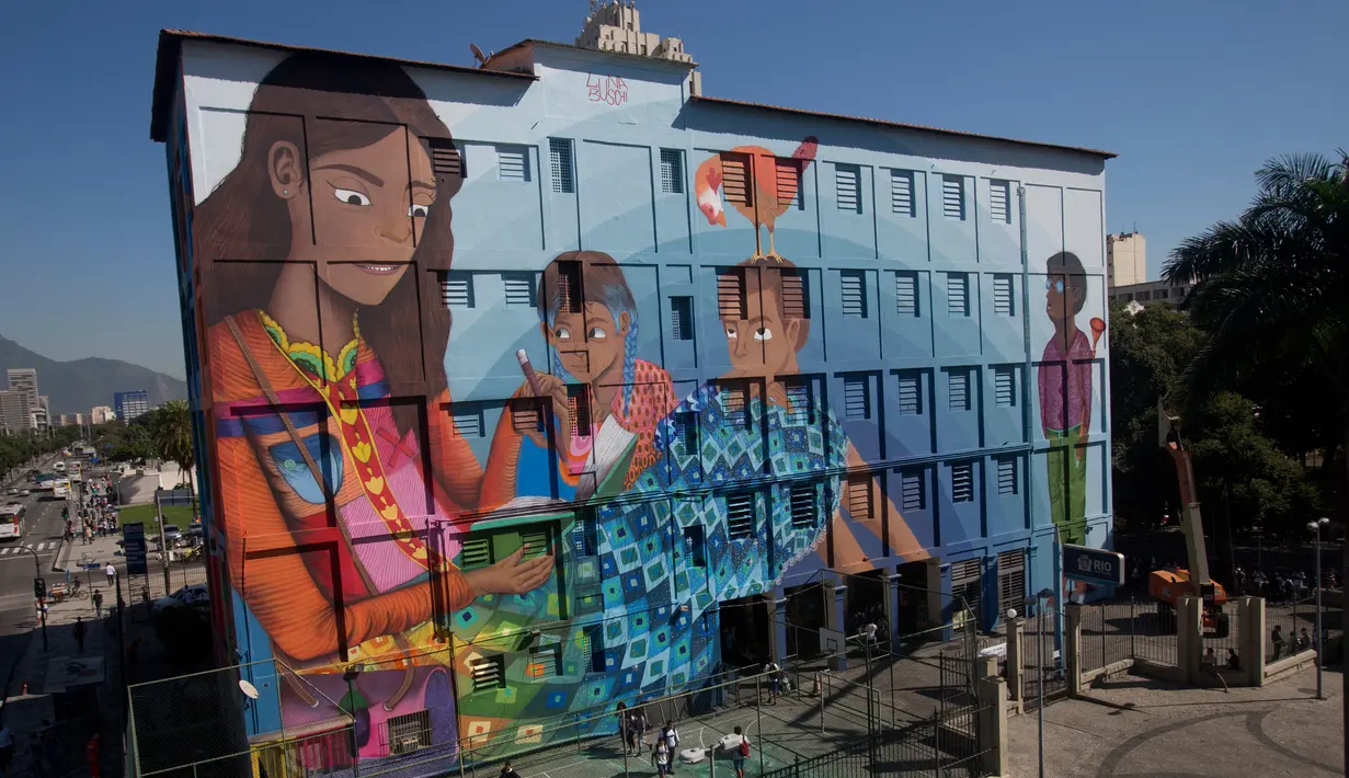 Mural berjudul 'Contos' yang dilukis oleh seniman Brasil, Luna Buschinelli, di dinding gedung sekolah Rio de Janeiro, (19/6). Mural tersebut mengisahkan seorang ibu buta huruf yang sedang membacakan buku cerita kepada anak-anaknya. (AP/Silvia Izquierdo)