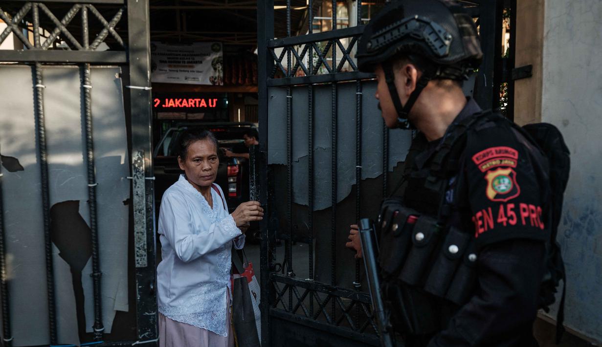 Peristiwa itu menimbulkan kepanikan di kalangan siswa dan guru yang sedang bersiap menjalankan ibadah salat Jumat. Tampak dalam foto, seorang wanita keluar dari gerbang SMAN 72 Jakarta di Jakarta pada Jumat 7 November 2025. (YASUYOSHI CHIBA/AFP)