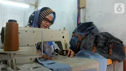 Perajin Risma Eljundi menyelesaikan pembuatan tas dari bahan celana jeans bekas di Legok, Tangerang, Banten, Senin (11/11/2019). Tas berbahan jeans dijual dengan harga Rp 150 ribu hingga Rp 250 ribu. (merdeka.com/Arie Basuki)