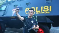 Beny Wahyudi selfie di depan rantis sebelum bertolak menuju Stadion Gelora Delta, Sidoarjo, untuk melawan Bhayangkara FC, Sabtu (19/9/2016). (Bola.com/Iwan Setiawan)