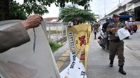 Petugas Satpol PP menertibkan Alat Peraga Kampanye (APK) di sepanjang Jalan Yos Sudarso, Jakarta Utara, Rabu (13/3). APK yang dipasang di sembarang tempat dan fasilitas umum melanggar SK KPU nomor 175. (merdeka.com/Iqbal S. Nugroho)