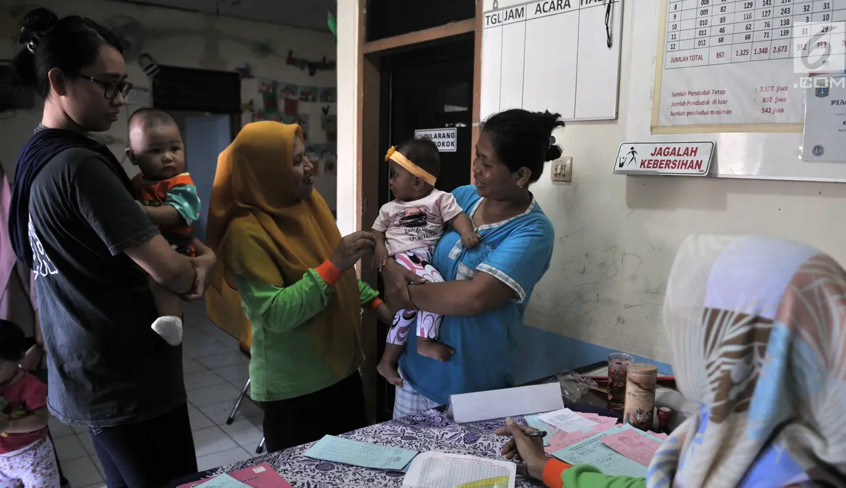 Warga saat mengikuti pemeriksaan rutin kesehatan bayi dan balita di Posyandu Ria Balita, Cipinang, Jakarta, Selasa (16/7/2019). Presiden Joko Widodo akan menjamin kesehatan ibu hamil, bayi, balita, dan anak usia sekolah. (merdeka.com/Iqbal Nugroho)