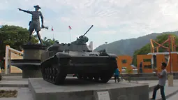 Pengunjung mengambil gambar tank tempur bersejarah TNI yang berada di Monumen Nani Wartabone di Kilometer Nol Kota Gorontalo, Sabtu (22/9). Dua tank tempur bersejarah TNI itu berjenis FV601 Saladin dan AMX-13 APC. (Liputan6.com/Arfandi Ibrahim)