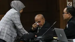 Mantan Kepala Staf Komando Strategis Angkatan Darat (Kostrad) Kivlan Zen berbincang dengan istrinya Dwitularsih sebelum menjalani sidang perdana di Pengadilan Negeri Jakarta Pusat, Selasa (10/9/2019). Kivlan menjalani sidang perdana kasus kepemilikan senjata api ilegal. (Liputan6.com/Angga Yuniar)