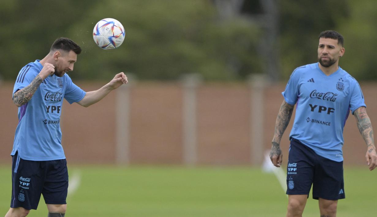 Pemain timnas Argentina Lionel Messi menunjukkan kebolehannya mengontrol bola dihadapan Nicolas Otamendi saat menjalani sesi latihan di Ezeiza, Argentina, Rabu (21/3/2023). (AFP/Juan Mabromata)