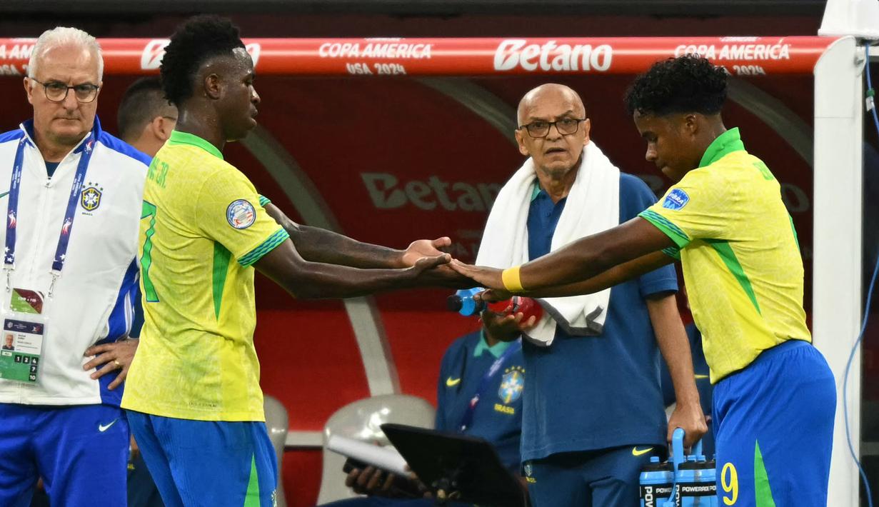 Pemain muda Brasil, Endrick (kanan) bersalaman dengan Vinicius Junior saat pergantian pemain pada laga Grup D Copa America 2024 melawan Kosta Rika di SoFi Stadium, Inglewood, California, Selasa (25/06/2024) WIB. (AFP/Pattrick T. Fallon)