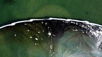 Foto udara menunjukkan penghalang dibuat untuk mencoba menghentikan tumpahan minyak ke Wetlands Talbert Marsh di Huntington Beach, California, Amerika Serikat, 4 Oktober 2021. Tumpahan sekitar 480 liter minyak mencemari laut dan pantai di California. (AP Photo/Ringo H.W. Chiu)