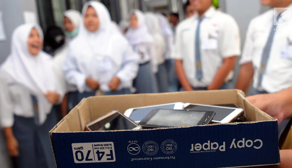 Sejumlah ponsel milik siswa dan siswi SMA 12 Cilenggang disita sementara selama mengikuti ujian nasonal berbasis komputer (UNBK) di Serpong, Tangerang, Senin (9/4). Sebanyak 1.983.568 siswa SMA dan MA di Tanah Air mengikuti UNBK. (Merdeka.com/Arie Basuki)
