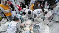 Peserta melakukan pemilahan sampah yang mereka kumpulkan selama mengikuti "SpoGomi World Cup 2023" Jepang, di mana semua tim berusaha untuk mengumpulkan sampah sebanyak mungkin. (AFP via Getty Images)