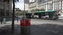 Sebuah bus melintasi kotak pembuangan urin bernama “Uritrottoir” yang disediakan pemerintah kota di Paris, 13 Agustus 2018. Menurut pejabat setempat, Uritrottoir itu diletakkan di lokasi-lokasi tempat pria sering kencing sembarangan. (AFP/Thomas SAMSON)
