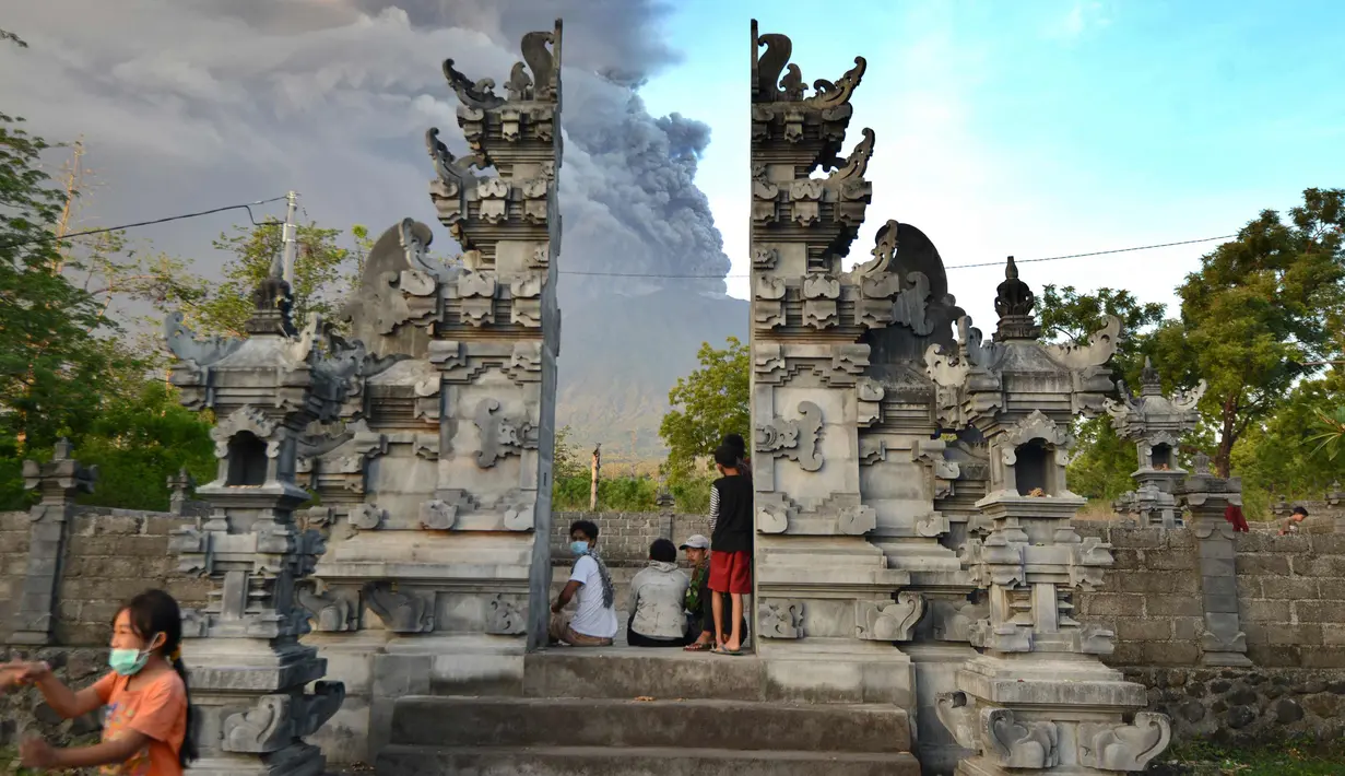 Warga melihat semburan abu vulkanik Gunung Agung di Kecamatan Kubu, Karangasem, Bali, Minggu (26/11). Semburan asap dan abu vulkanik Gunung Agung mencapai ketinggian 1.500 meter dari puncak Gunung Agung. (AFP/Sonny Tumbelaka)