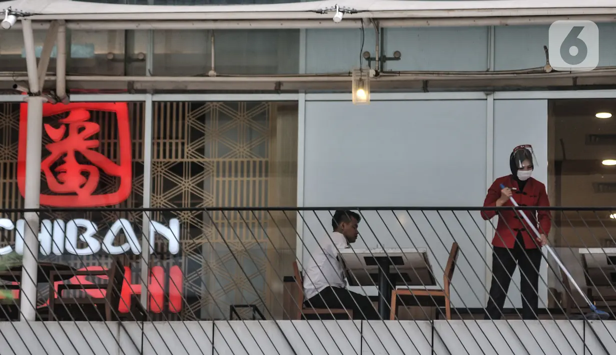 Pekerja membersihkan area restoran kawasan Soedirman, Jakarta, Minggu (11/10/2020). Gugus Tugas Percepatan Penanganan Covid-19 mencatat adanya pelambatan kenaikan kasus positif atau aktif di Ibu Kota selama sebulan pemberlakukan PSBB yang diperketat. (merdeka.com/Iqbal S. Nugroho)