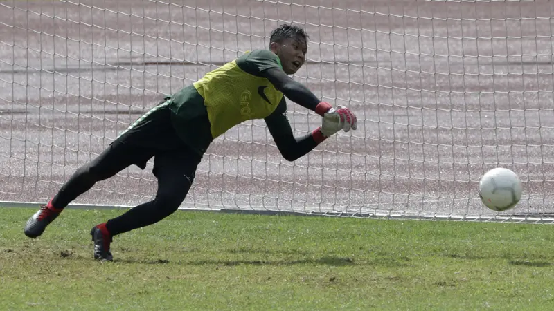 Kiper Timnas Indonesia U-22, Awan Setho, menepis bola saat latihan. (Bola.com/Yoppy Renato)