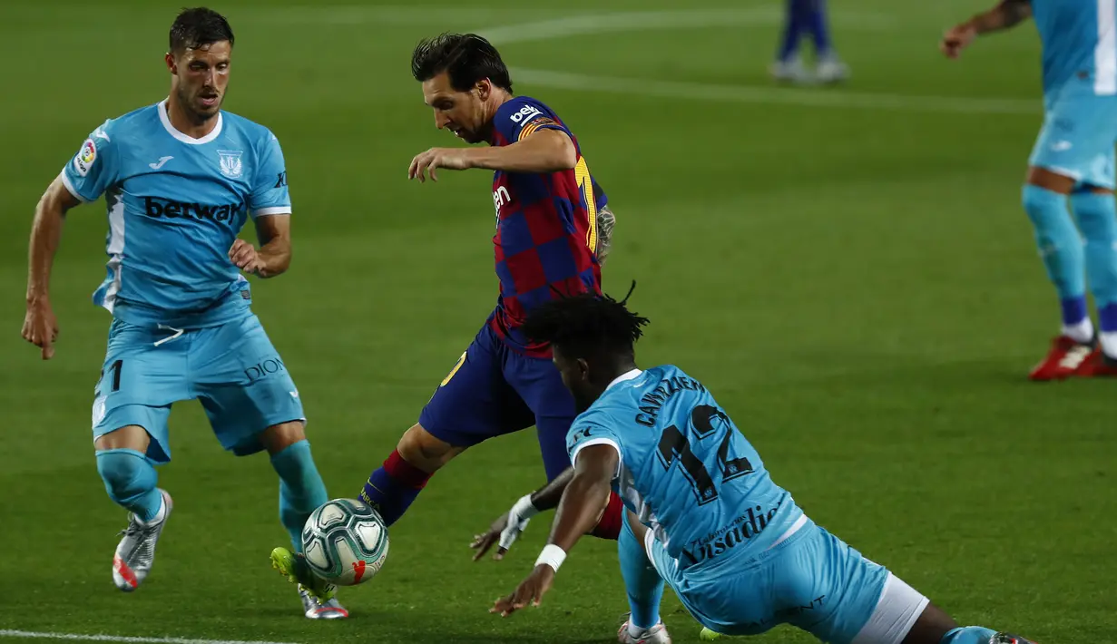 Pemain Barcelona Lionel Messi (tengah) berebut bola dengan Leido Chidozie Awaziem (kanan) dan Ruben Perez saat menghadapi Leganes pada pertandingan La Liga Spanyol di Camp Nou, Barcelona, Spanyol, Selasa (16/6/2020). Barcelona menang 2-0 lewat gol Ansu Fati dan Lionel Messi. (AP Photo/Joan Montfort)